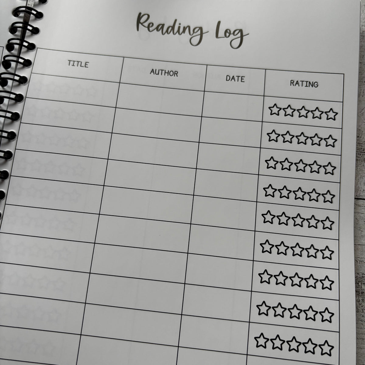 Reading log sheet with star rating system on a notebook page.