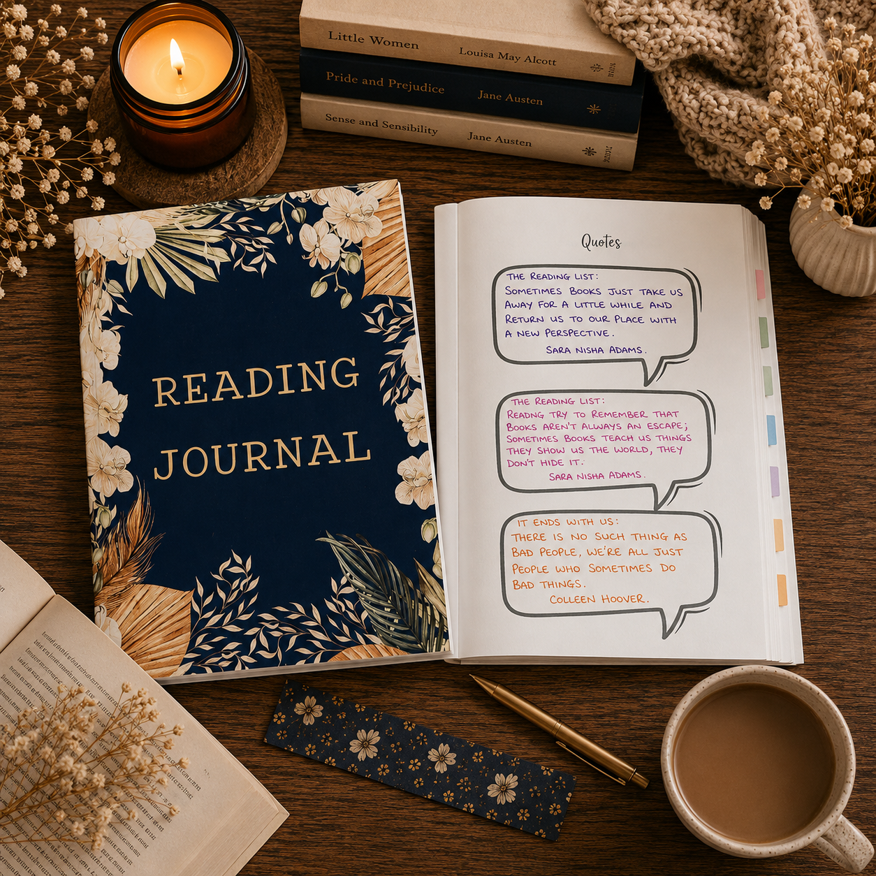 A styled flat-lay of a navy blue and gold floral 'READING JOURNAL' on a wooden table, next to an open notebook with handwritten notes, a lit candle, books, dried flowers, a mug, and a scarf.