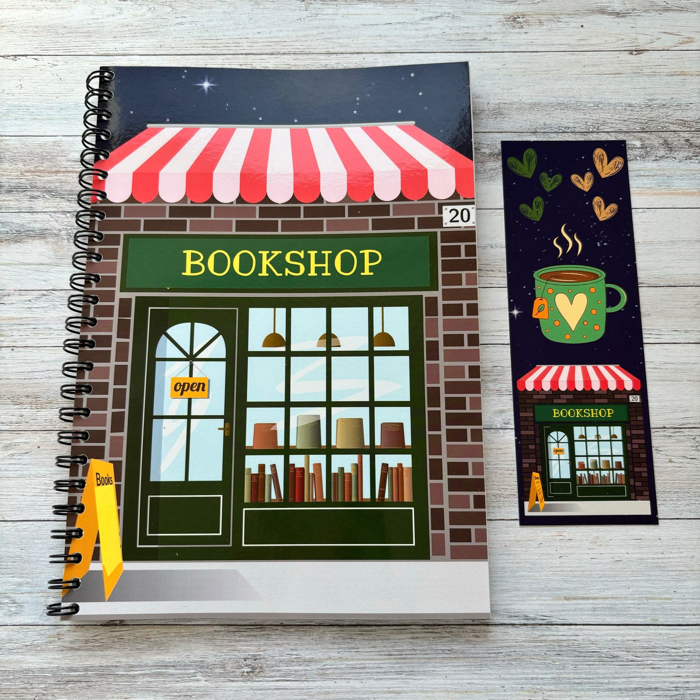A reading log book with a bookshop cover design, including a bookmark, on a wooden background.