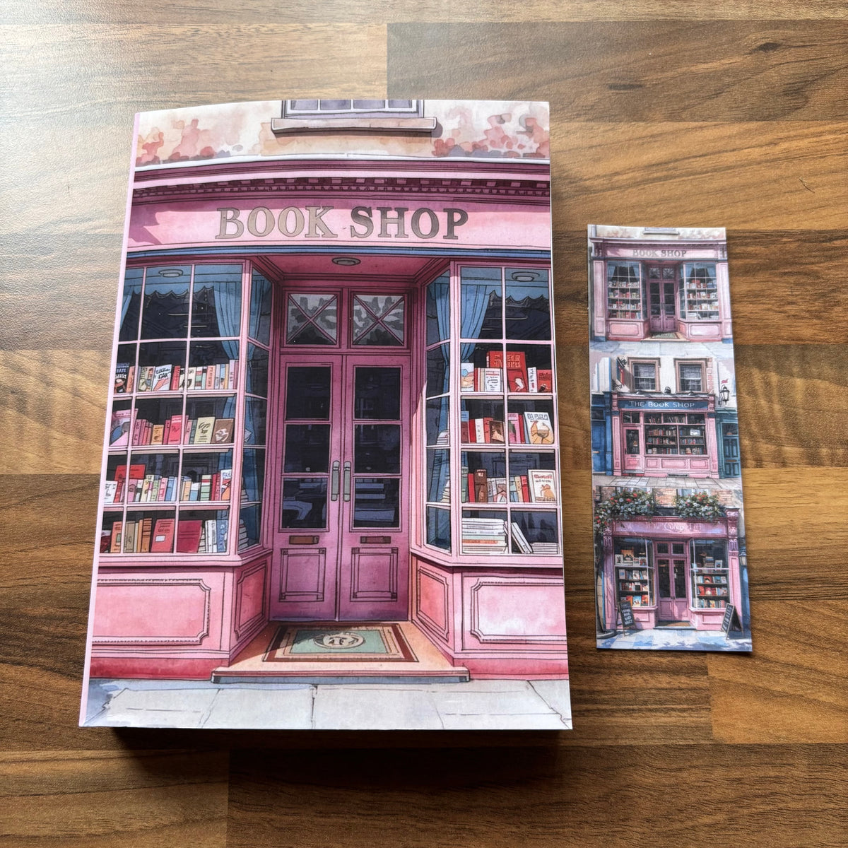 400 page book journal with illustration of a pink bookshop on a wooden surface with a cute matching bookmark
