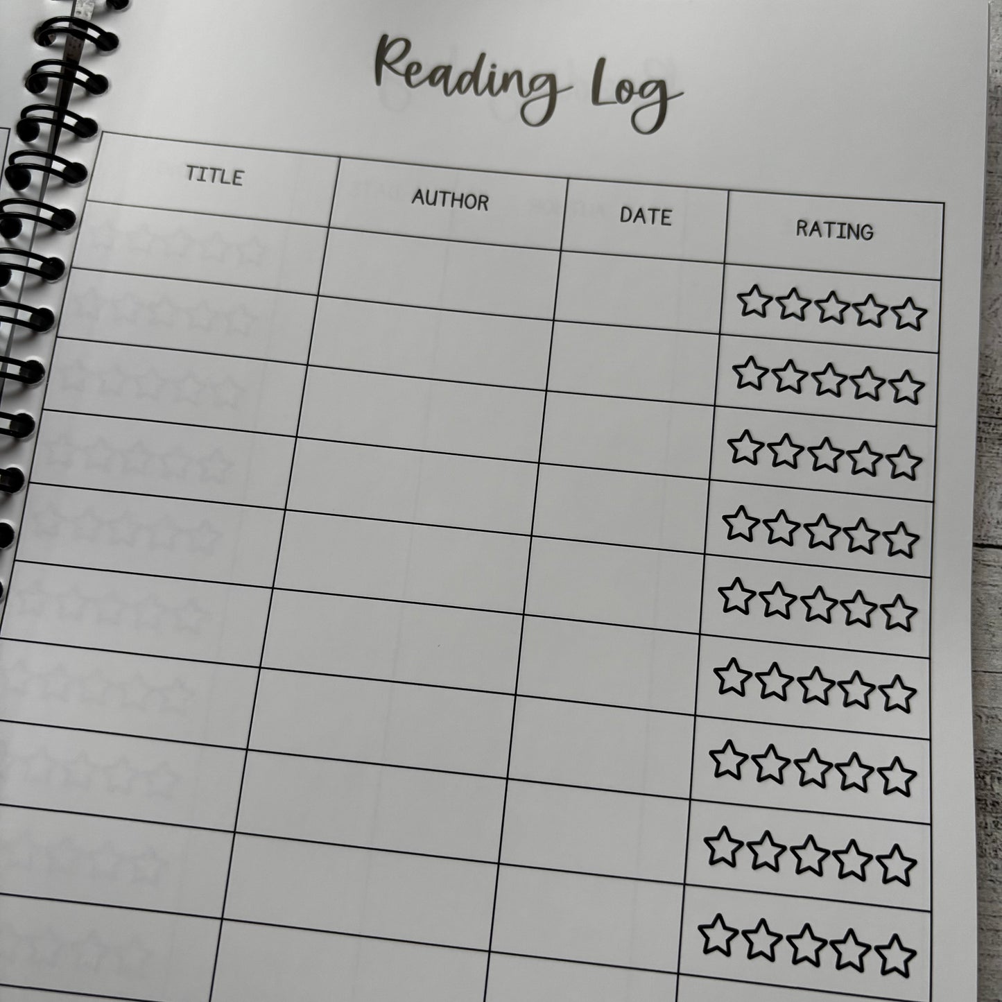 Reading log sheet with star rating system on a notebook page.