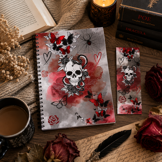 A gothic-dark romance themed spiral reading journal and matching bookmark set displayed on a rustic wooden table with a candle, books, dried flowers, and a cup of tea. The notebook cover features a central black and white skull surrounded by red roses, butterflies, and hearts on a grey and red watercolor background.
