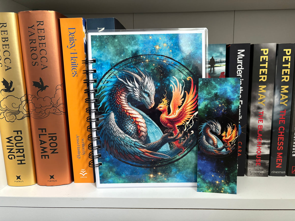 A fantasy-themed reading journal with a colorful illustration of a bird-like creature resembling a phoenix or a dragon, surrounded by a starry night background. The journal is wire-bound and has a title and author's name on the cover.