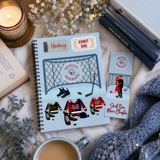 A styled flat-lay featuring a spiral-bound notebook and matching bookmark with ice hockey-themed illustrations, including a goal net, skates, jerseys, and phrases like 'Hockey Romance' and 'Just One More Chapter.' The scene includes a lit candle, books, dried flowers, a mug of coffee, and a chunky knit sweater on a soft fabric surface.