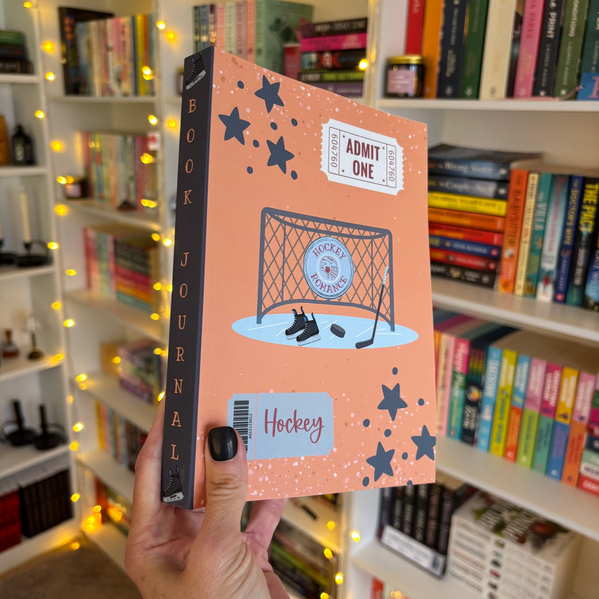 Book journal with hockey theme held in front of a bookshelf