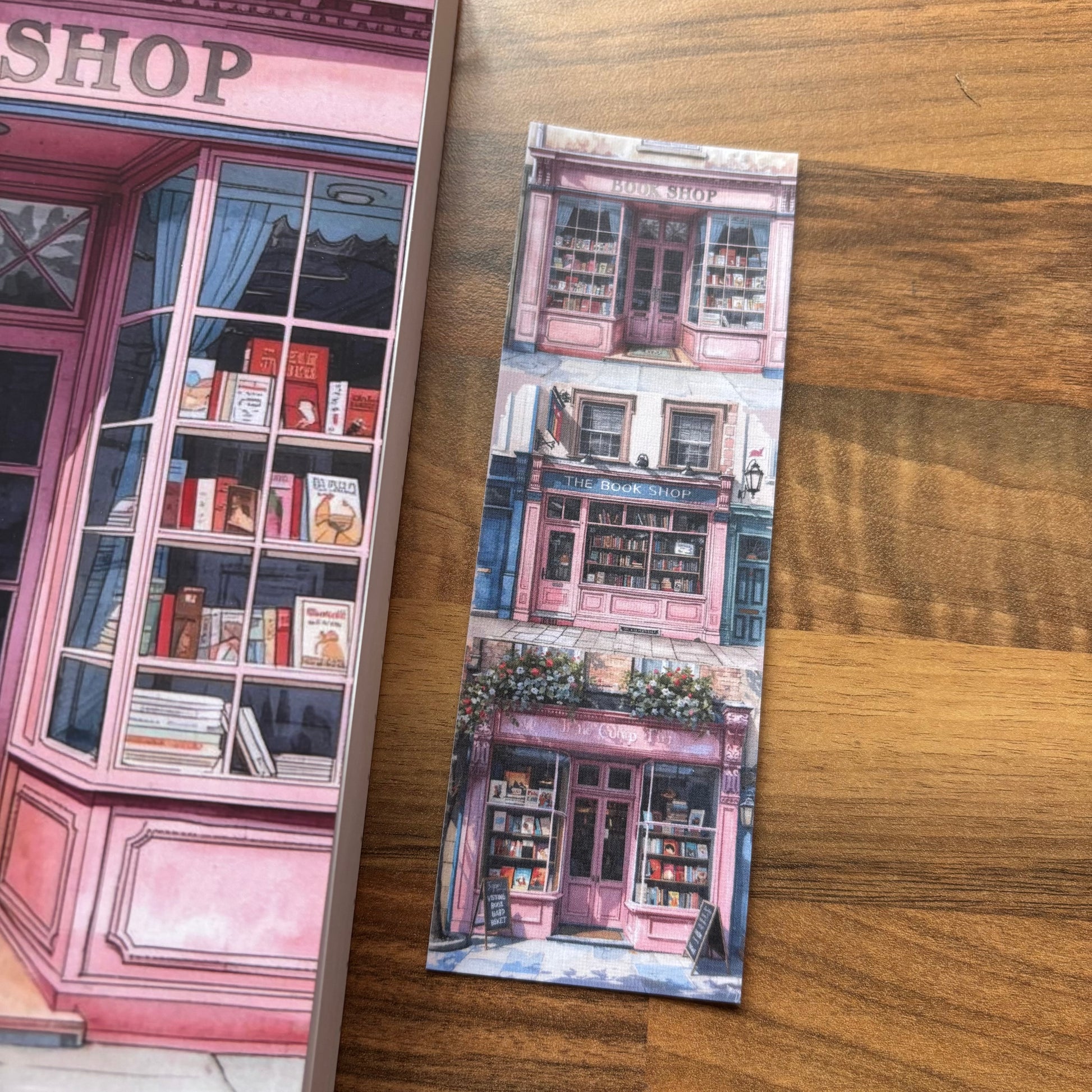 Book with a pink shop illustration on a wooden surface