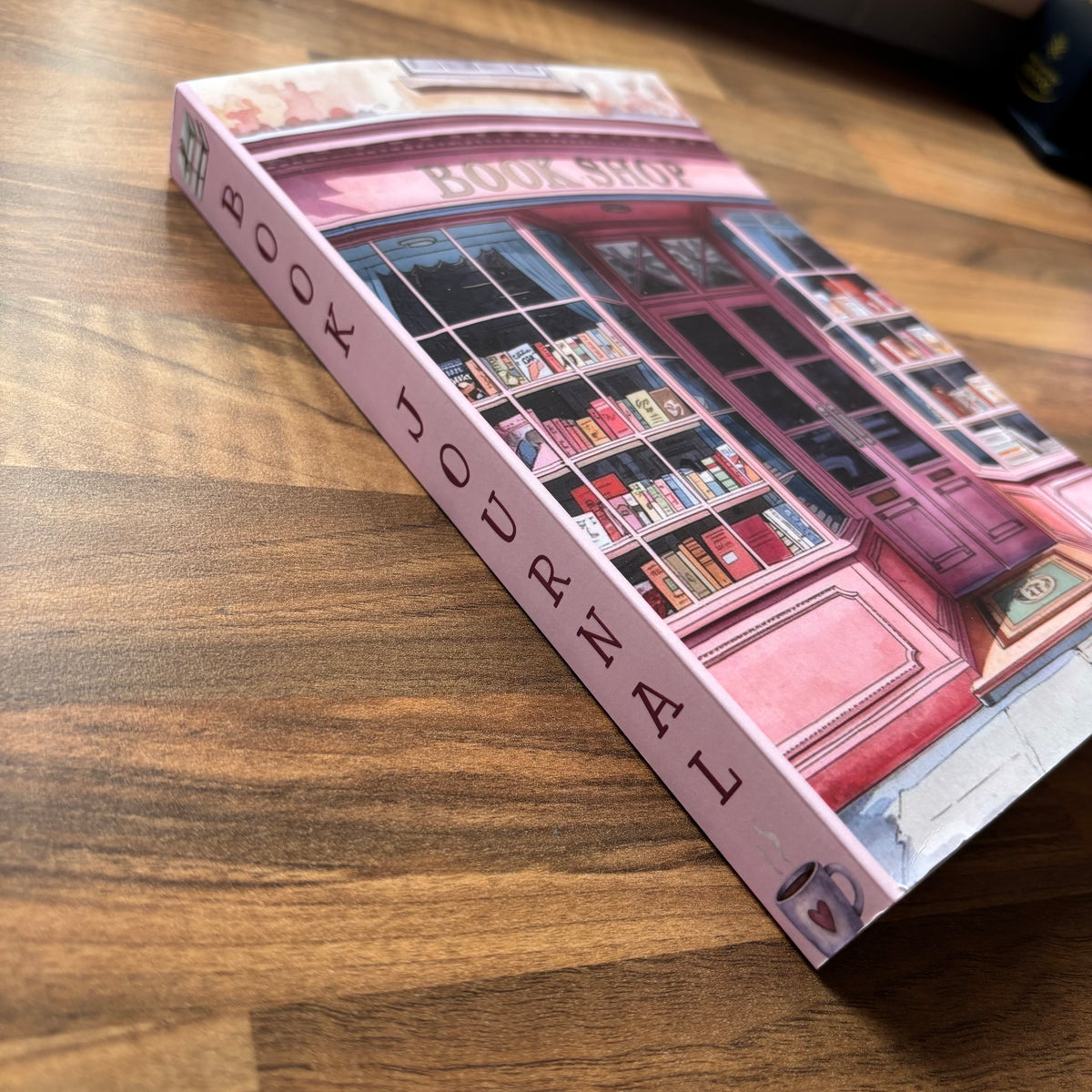 Book-themed journal with illustration of a bookshop on a wooden surface